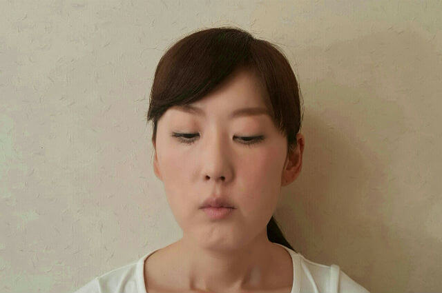 4.顔は正面を向いたまま両目をパッと開き、目線を下方向へ動かして　 3秒間キープします。